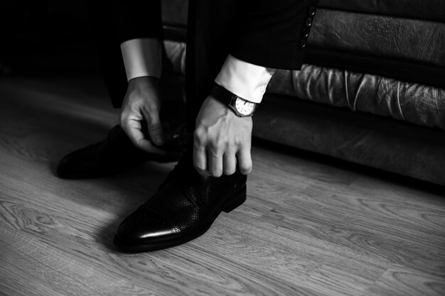 Мужчина завязывает шнурки на своей обуви