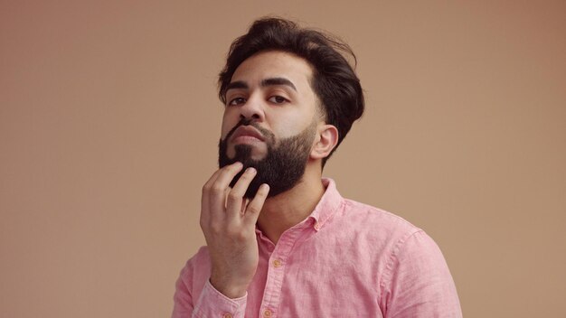 Man touches his hair an looking at camera Good groomed man with beard