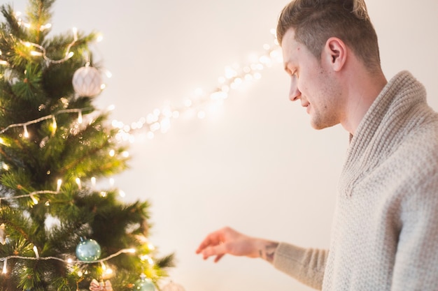 Man touching christmas tree