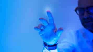 Foto gratuita uomo che tocca lo schermo blu futuristico