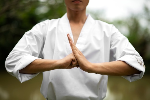 Foto gratuita uomo che si allena nel taekwondo all'aperto in natura