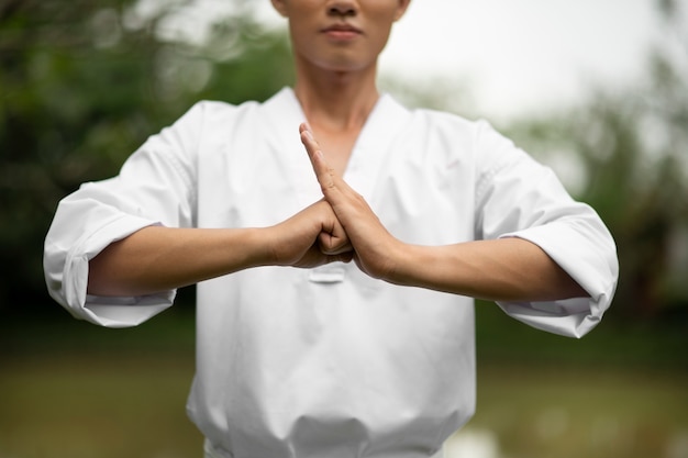 Foto gratuita uomo che si allena nel taekwondo all'aperto in natura