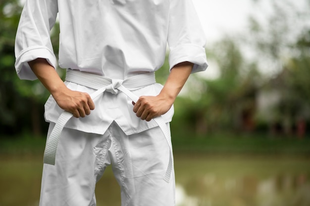 Foto gratuita uomo che si allena nel taekwondo all'aperto in natura