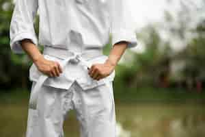 Foto gratuita uomo che si allena nel taekwondo all'aperto in natura