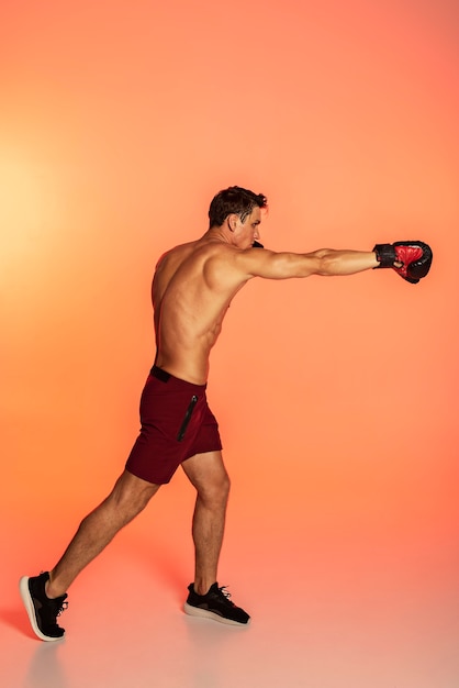 Man training with boxing gloves full shot