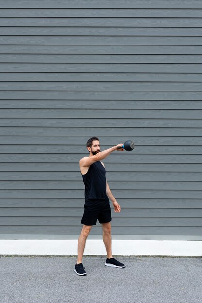 Man training with kettle bell full shot