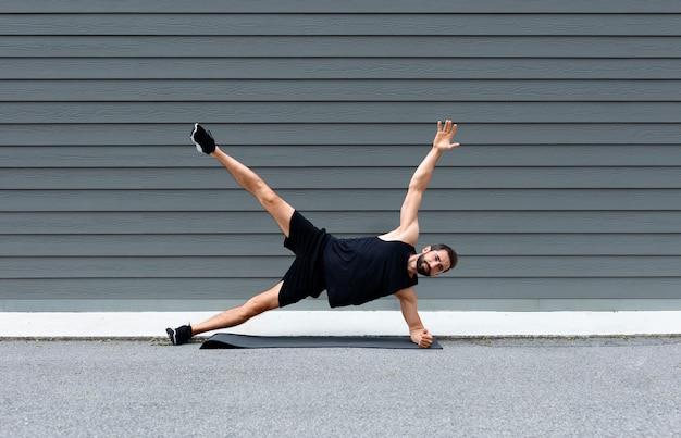 Man training on yoga mat full shot