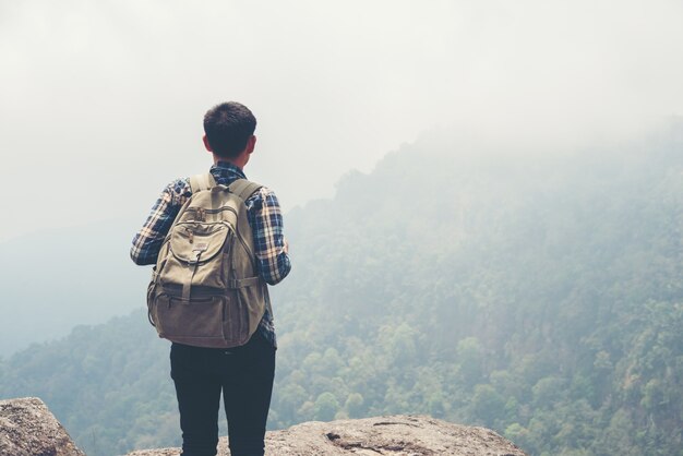 Человек-путешественник с рюкзаком на вершине горы. Концепция Travel Lifestyle.