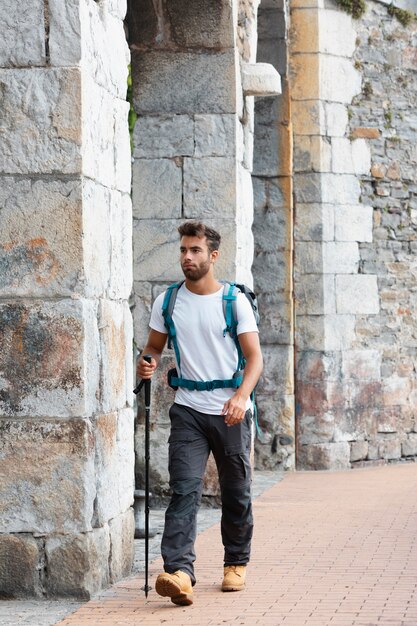 Man traveling alone in mutriku while having his essentials in a backpack