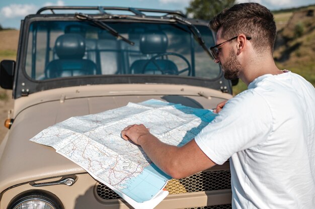 Man traveling by car and checking map