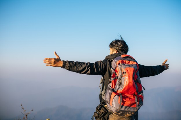 山でのハイキングのバックパックと一緒に旅行する人