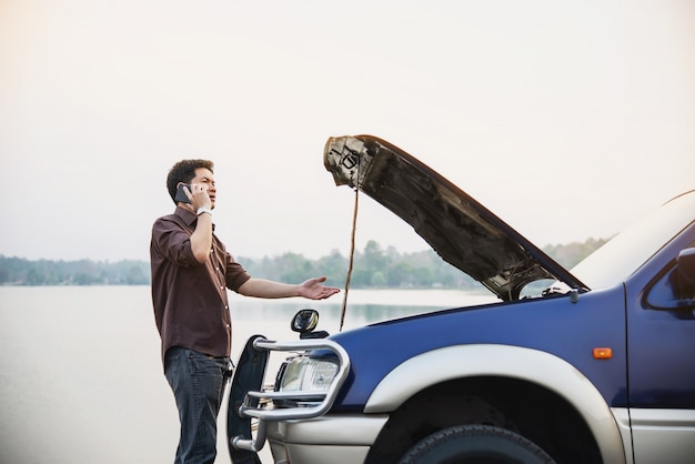 Free photo man try to fix a car engine problem on a local road chiang mai thailand