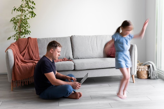 Man trying to work on laptop from home while her children are running around