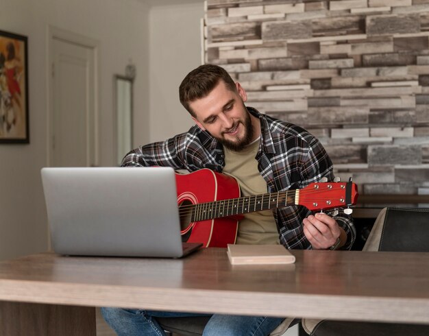 Man tuning guitar medium shot