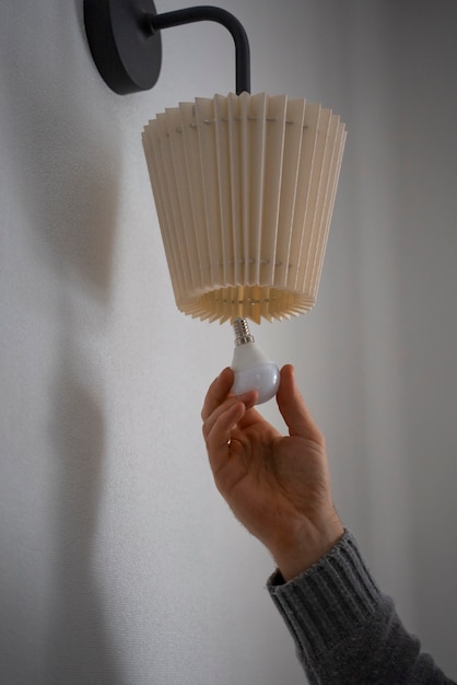 Man turning off light bulb during energy crisis