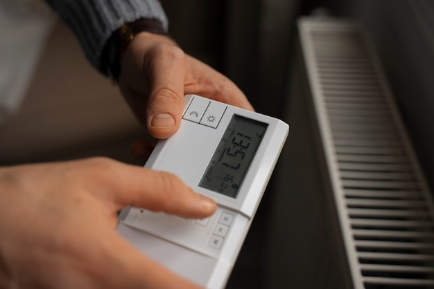 Foto gratuita uomo che spegne il termostato durante la crisi energetica