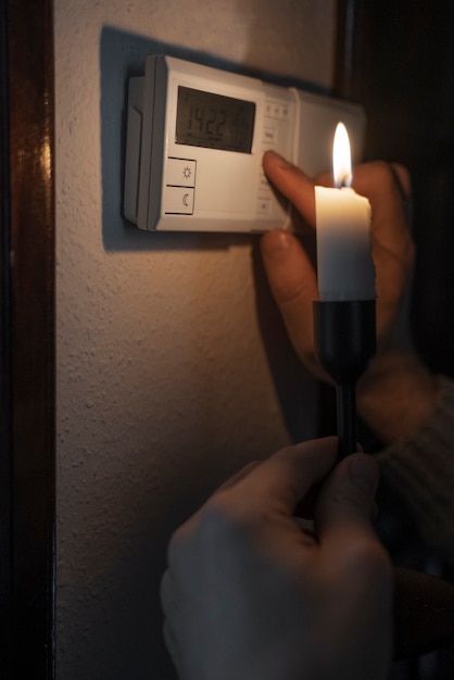 Free photo man turning off thermostat during energy crisis