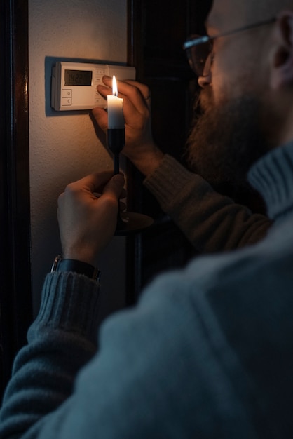 Foto gratuita uomo che spegne il termostato durante la crisi energetica