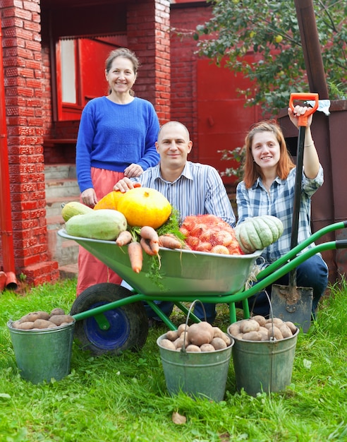 Free photo man and two women with  harvested vegetables