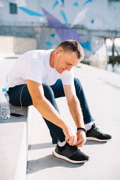 Man tying his right shoe laces