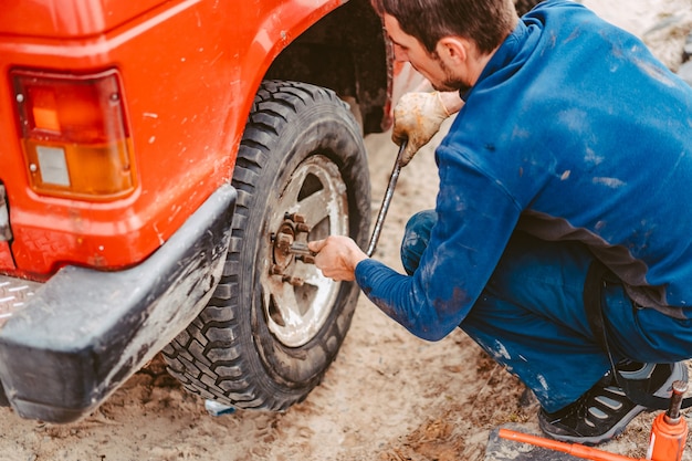 Man unscrews the bolts on the wheel