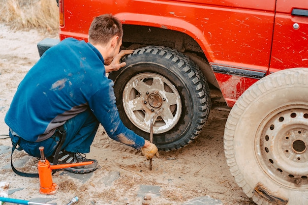 Man unscrews the bolts on the wheel