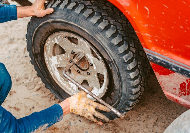 Man unscrews the bolts on the wheel