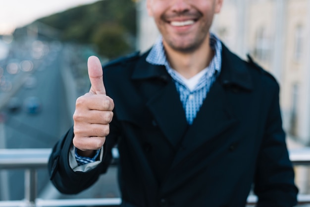 Man in urban environment with thumb up