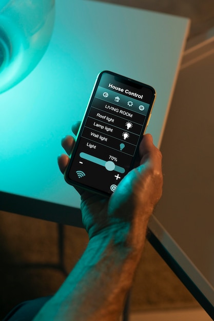 Бесплатное фото Человек, использующий смартфон в своем автоматизированном доме