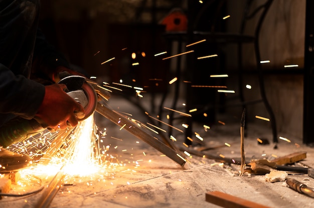 Free photo man using angle grinder with sparks