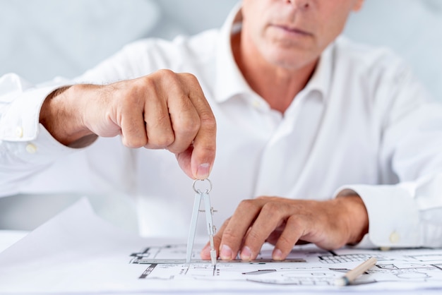 Man using a compass for architectural plan