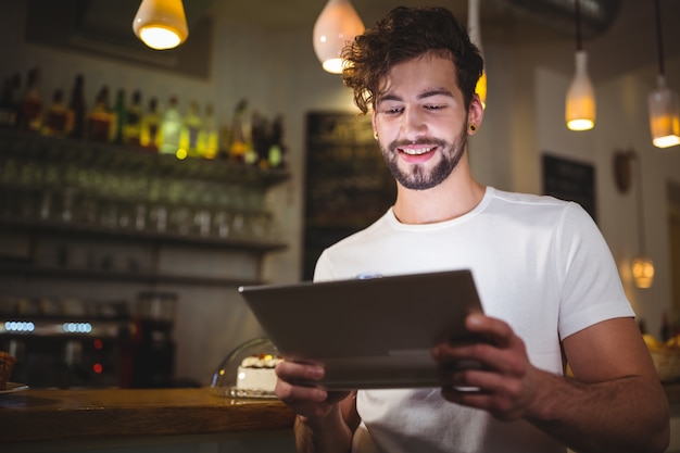 Man using digital tablet in cafe