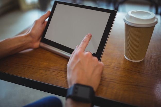 Man using digital tablet in cafe