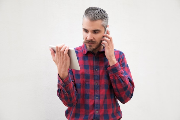 Человек с помощью цифрового планшета и говорить на смартфон