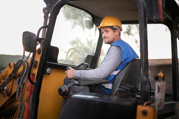 Free photo man using an excavator for digging on day light