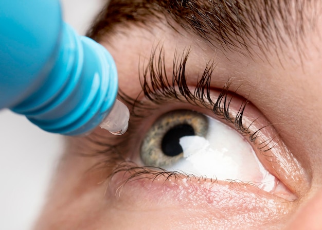 Man using eye drops close-up