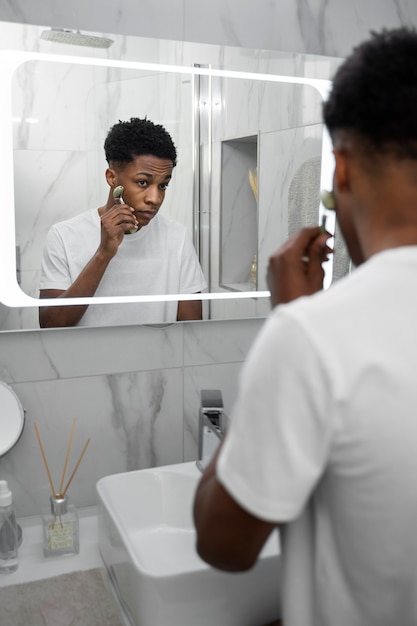 Man using face tool at home close up