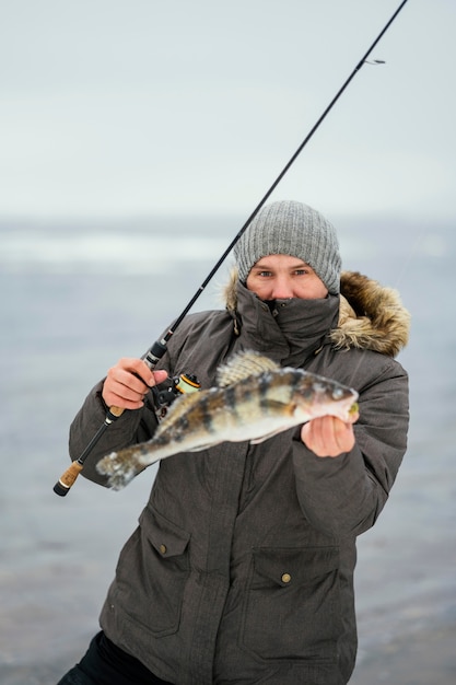 Free photo man using a fishing rod to catch fish