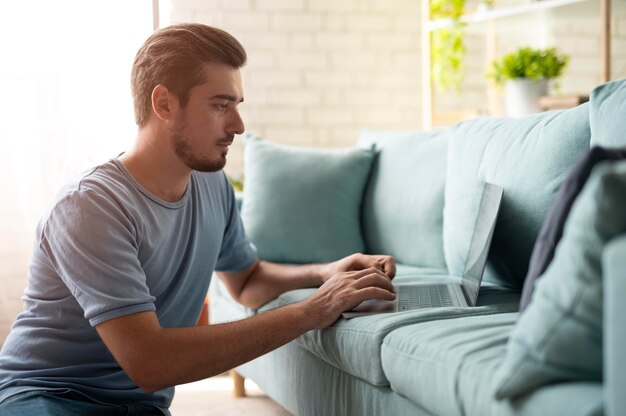 Man using his laptop with digital assistant at home