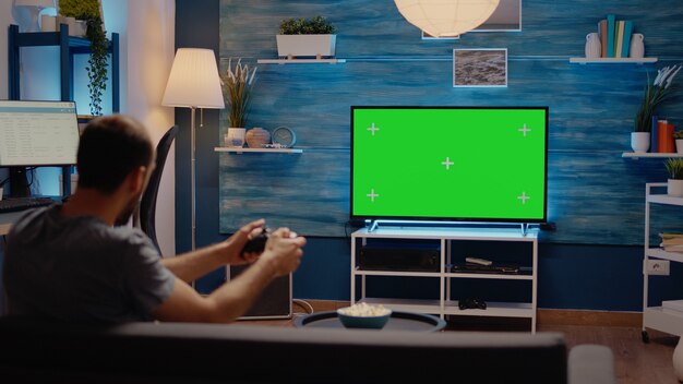 Man using joystick on green screen background display