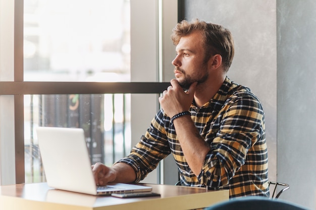 Foto gratuita uomo che utilizza computer portatile nella caffetteria