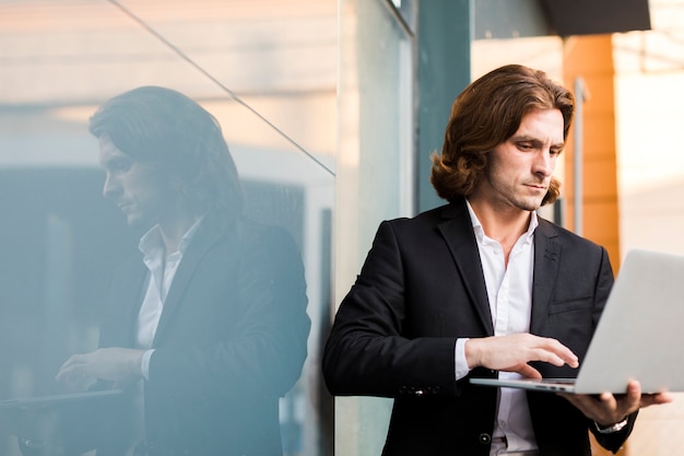 Man using a laptop outdoor with copy space