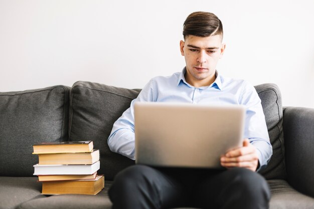 Man using laptop on sofa