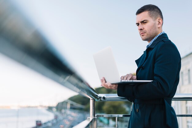 Man using laptop in urban environment