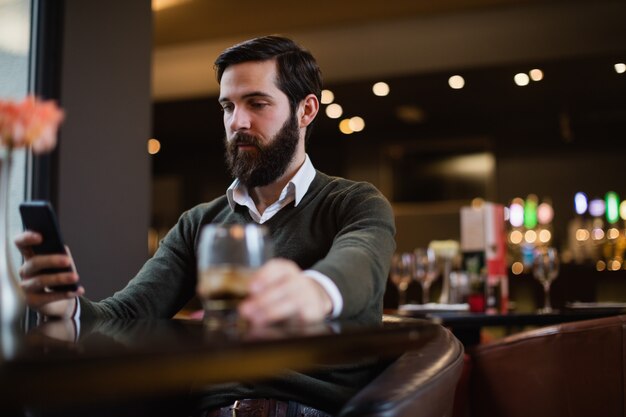 Man using mobile phone in bar