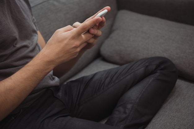 Man using mobile phone on sofa