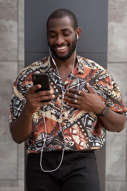 Man using modern smartphone with earphones