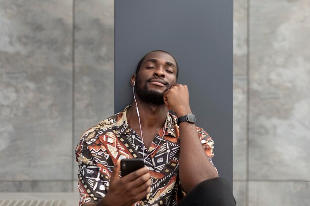 Man using modern smartphone with earphones