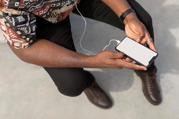 Man using modern smartphone with earphones