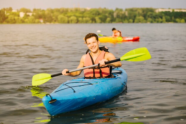 Man using paddle while kayaking in water